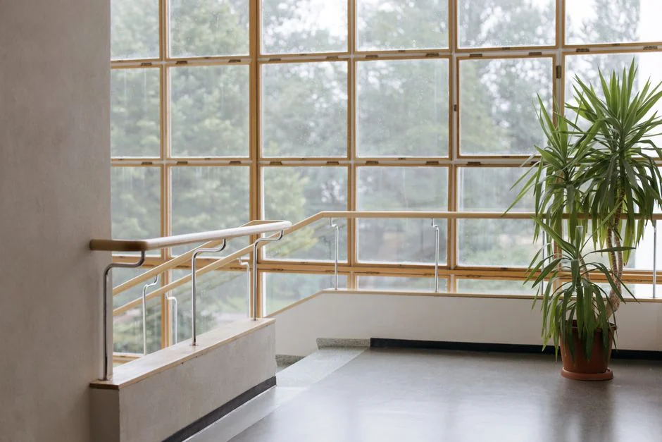 Spacious and contemporary office interior with glass partitions, stylish furniture, and vibrant wall art.
